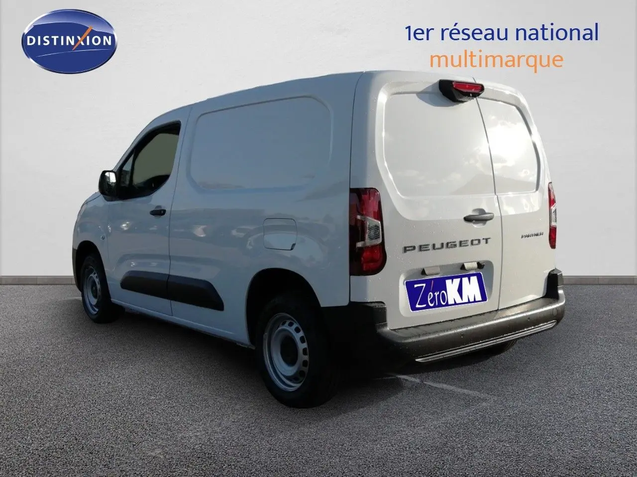 Vue 3/4 arrière droite d'un Peugeot Partner blanc Kaolin utilitaire avec porte latérale et hayon fermé.
