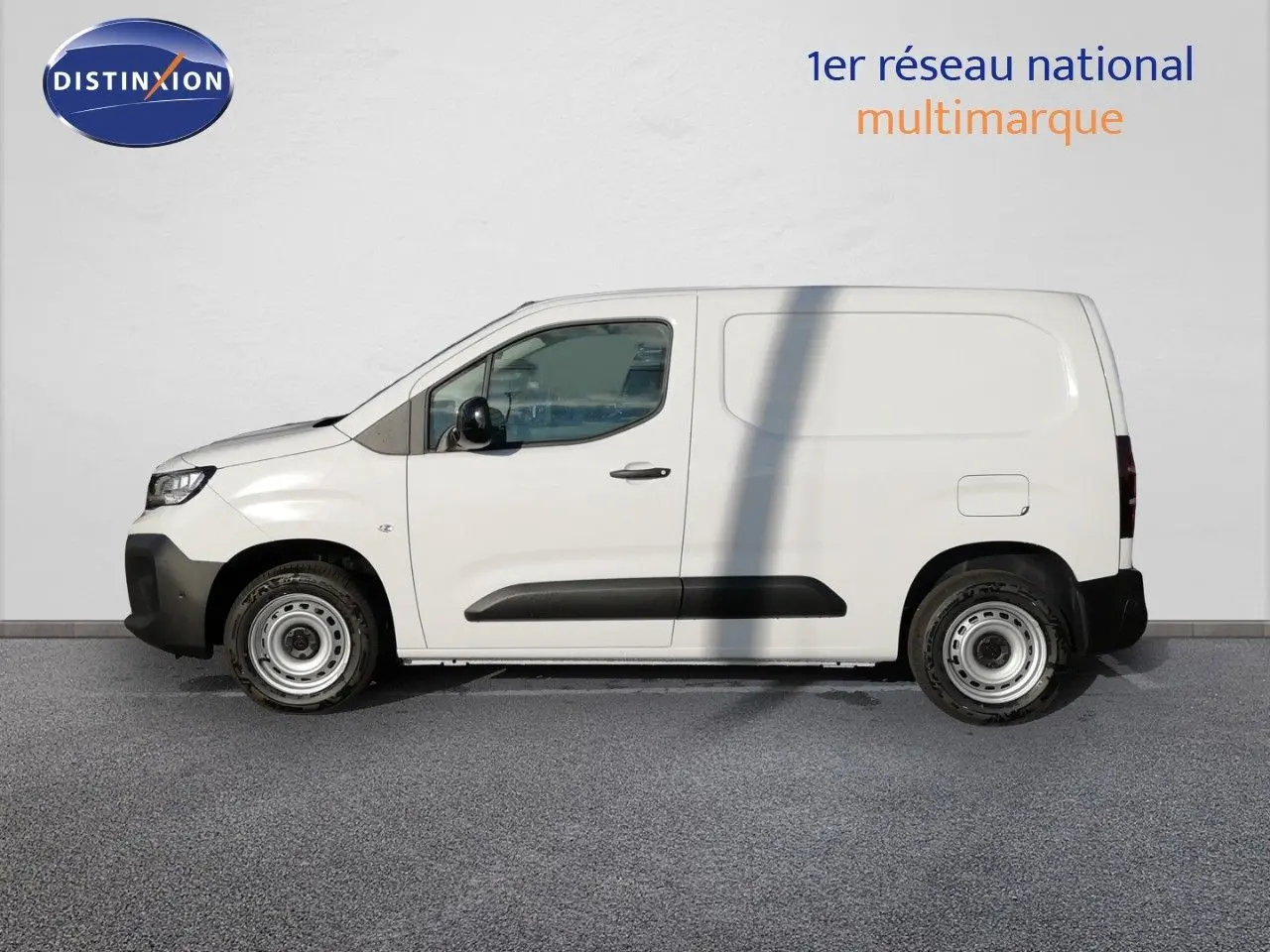 Peugeot Partner blanc Kaolin vu de profil côté gauche, fourgonnette utilitaire avec protections noires sur les portières.
