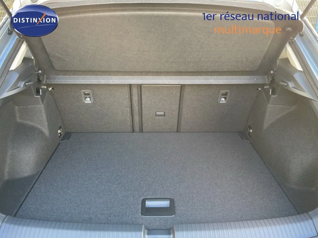 Coffre ouvert vu de l'arrière d'un Volkswagen T-Roc gris pyrite, montrant un espace de chargement propre et spacieux.