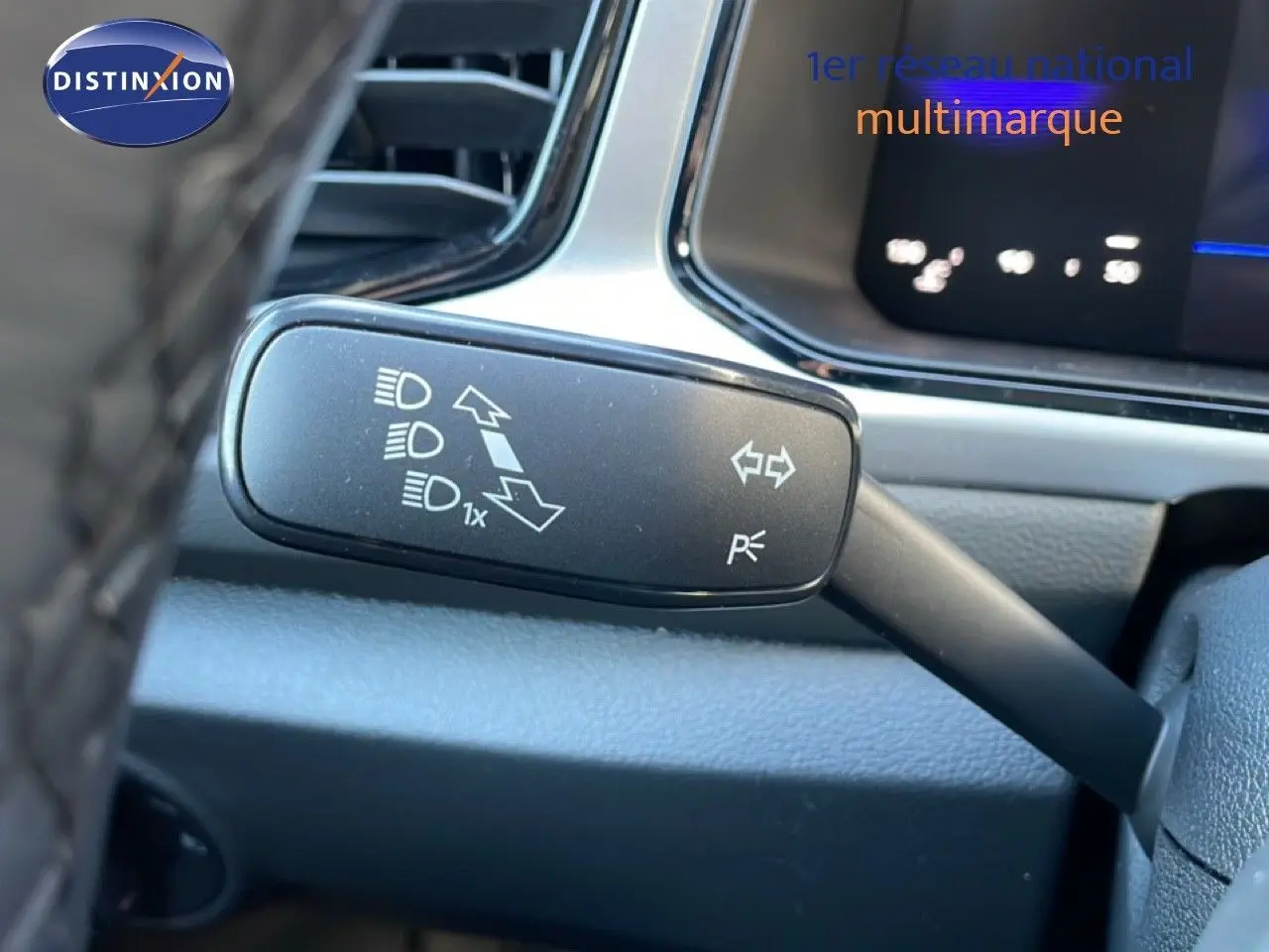 Gros plan sur la commande de clignotant à gauche dans l’habitacle du Volkswagen T-Roc gris pyrite 2025.