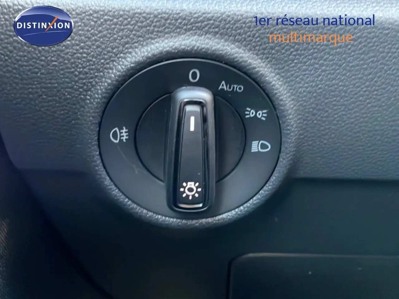 Gros plan sur la molette de commande des phares du Volkswagen T-Roc 2025 en intérieur noir texturé.