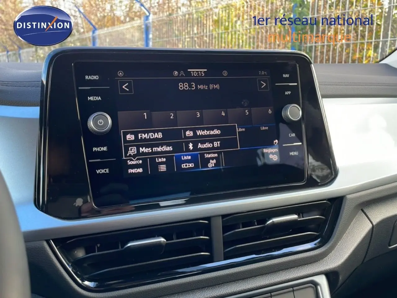 Écran tactile central du tableau de bord du Volkswagen T-Roc gris Pyrite, affichant les options radio et multimédia.