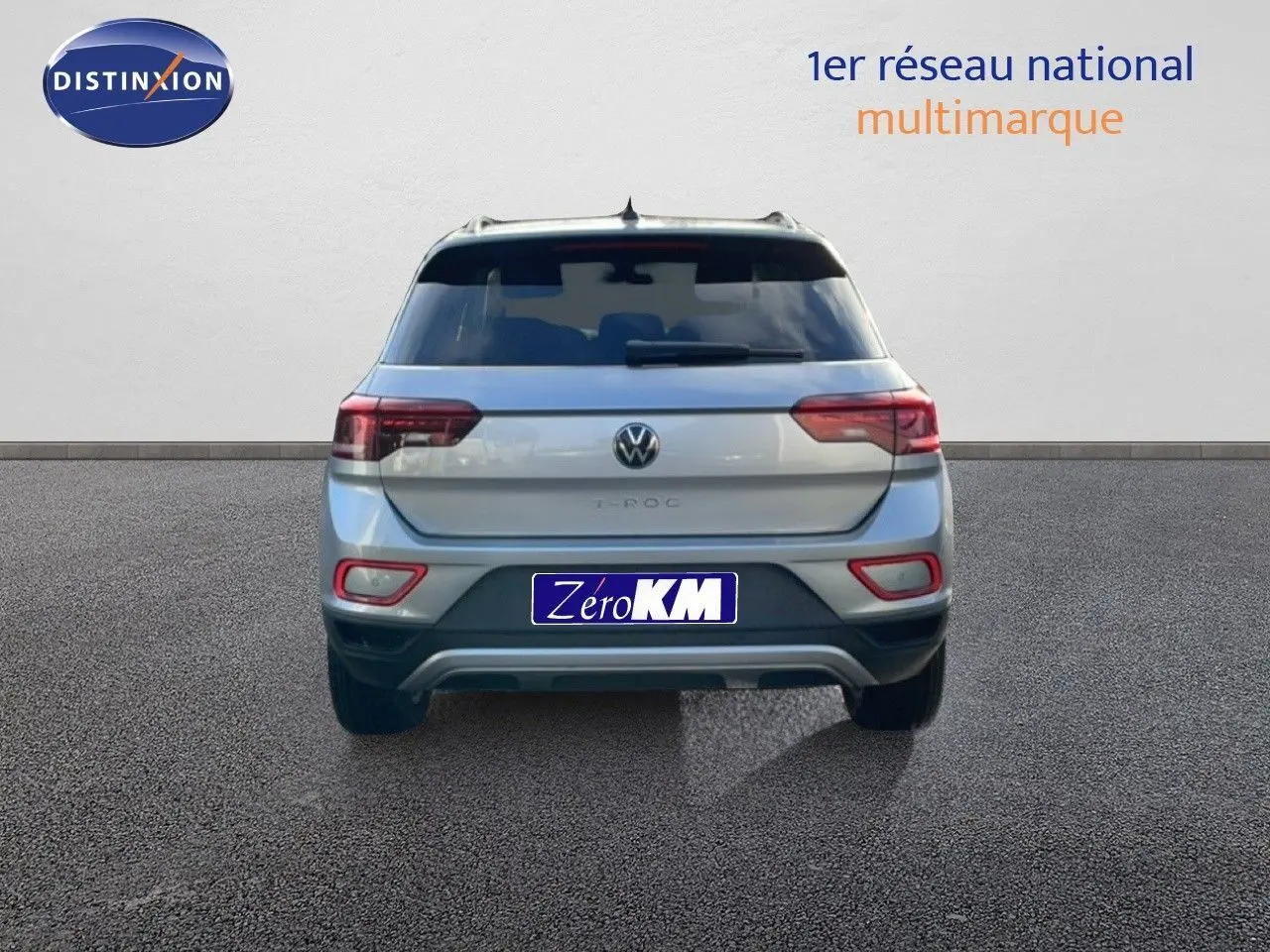 Vue arrière d'un Volkswagen T-Roc gris pyrite métal 2025 avec feux LED et plaque Zéro KM visible.
