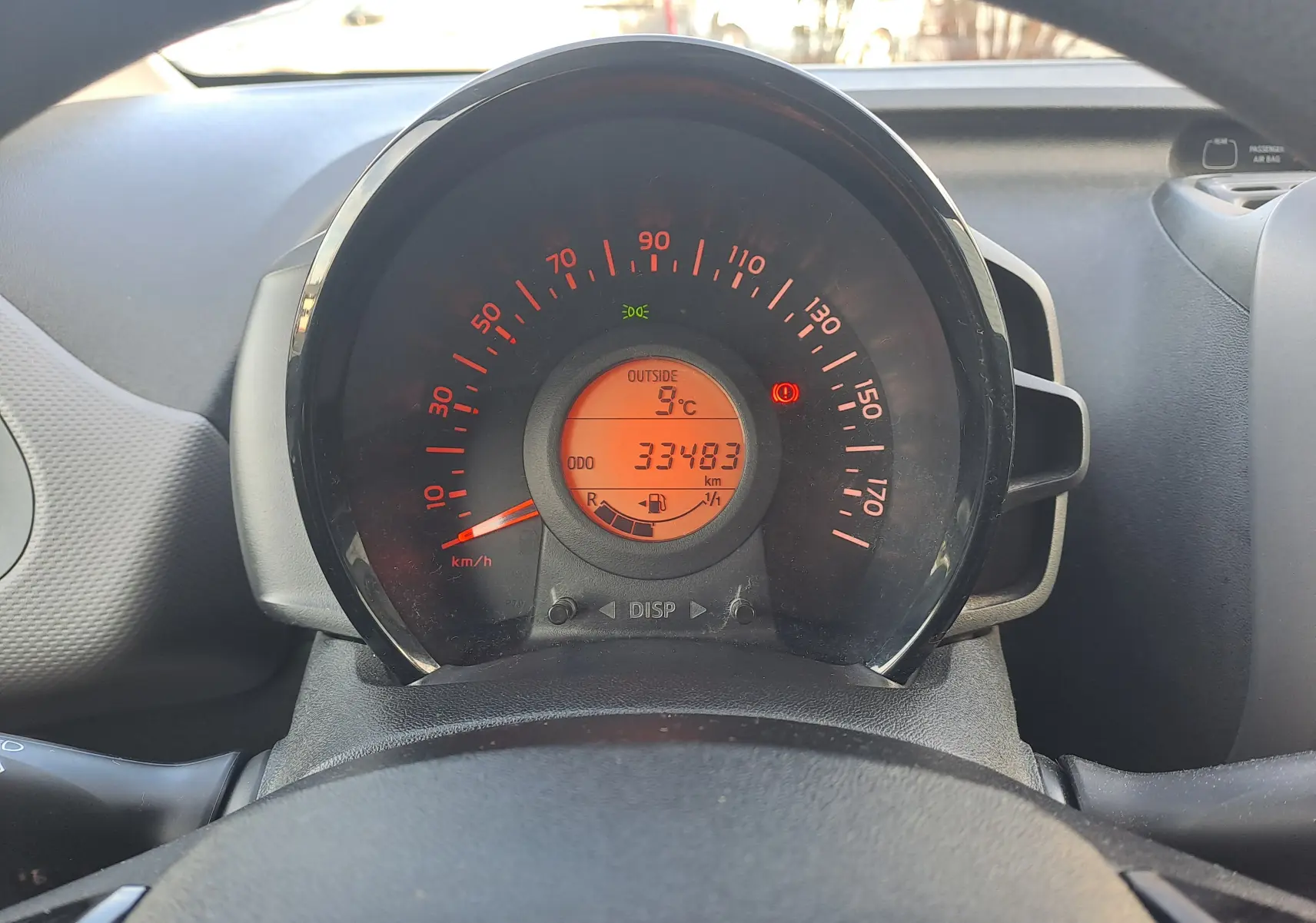 Vue rapprochée du compteur de vitesse orange et noir du tableau de bord d'une Peugeot 108 noire de 2020.