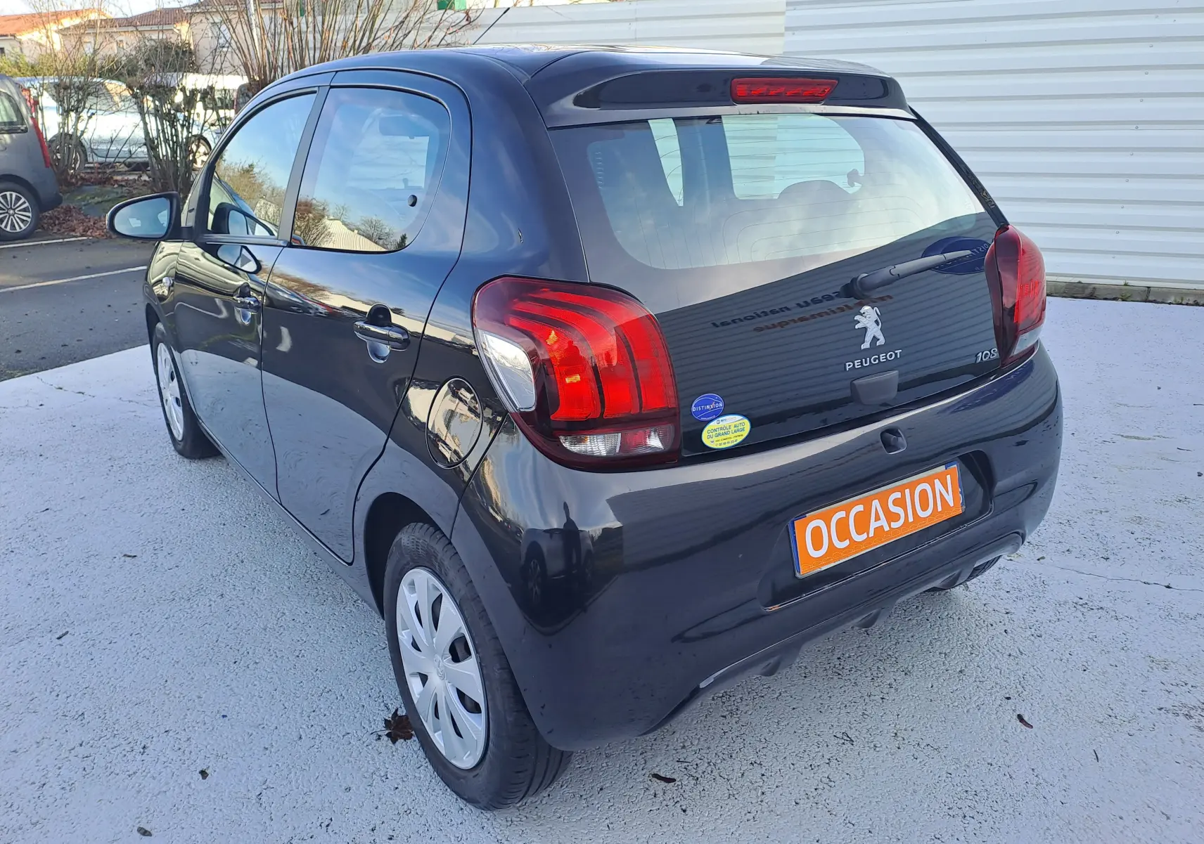 Vue 3/4 arrière droite d'une Peugeot 108 noire 5 portes avec feux arrière rouges et plaque "OCCASION" visible.