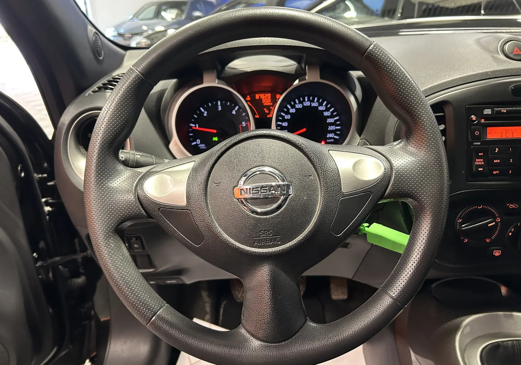 Vue intérieure centrée sur le volant Nissan dci 110 Acenta noir avec tableau de bord et commandes visibles.