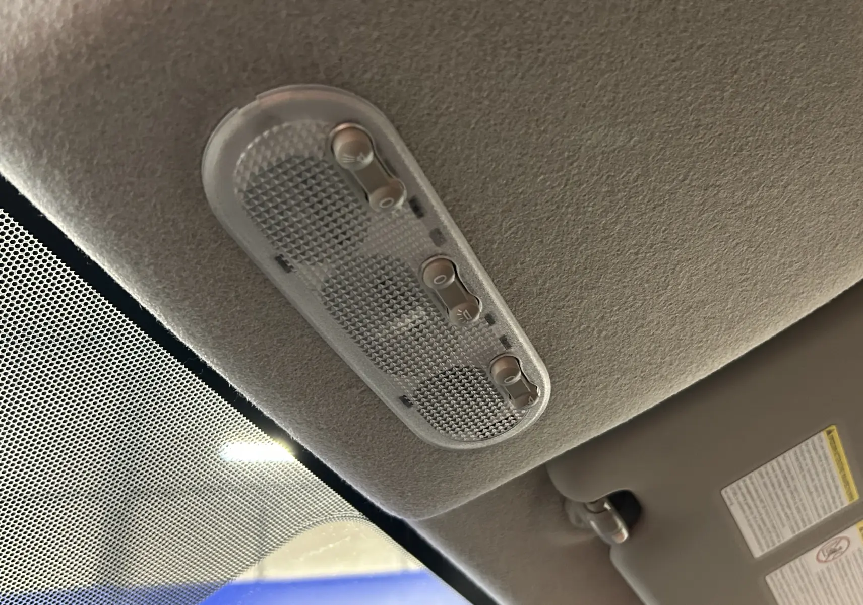 Plafonnier intérieur avec interrupteurs de lumière, vue en contre-plongée depuis l'avant du Nissan Juke.