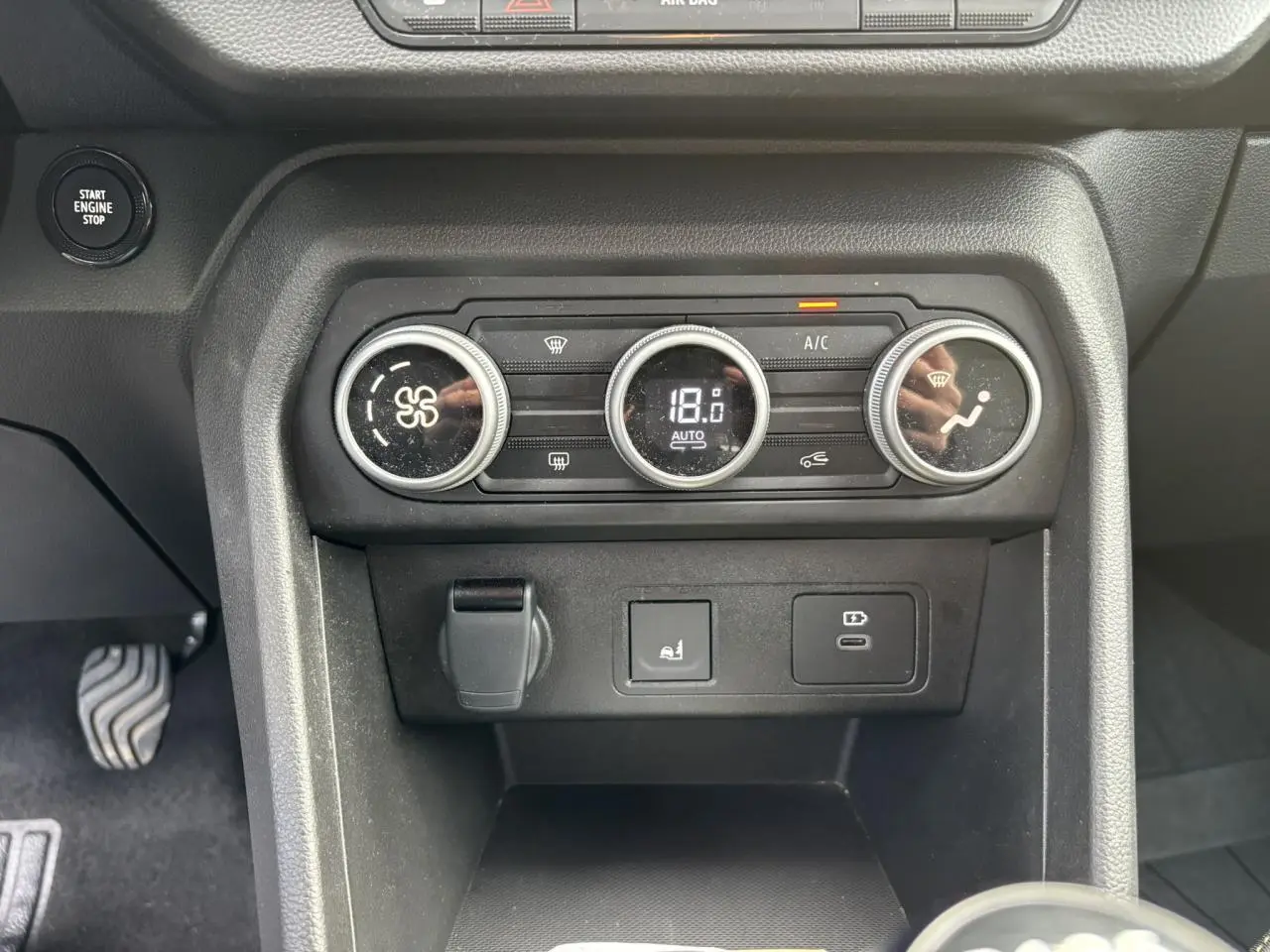 Vue rapprochée de la console centrale de la Dacia Sandero Stepway 2025, avec commandes climatisation automatique et prises USB.