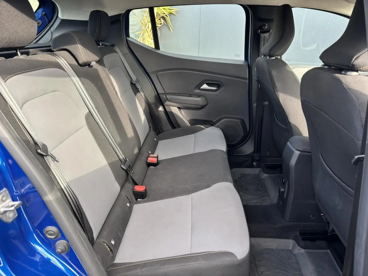 Vue intérieure côté gauche des sièges arrière gris et noirs du Dacia Sandero Stepway Bleu Iron 2025.