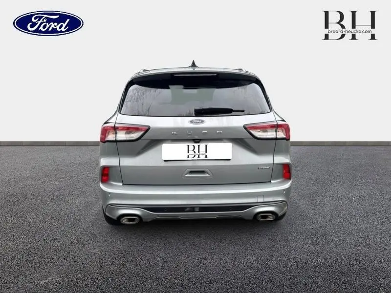 Vue arrière d'un Ford Kuga gris Solar métallisé avec double sortie d'échappement et vitres arrière surteintées.