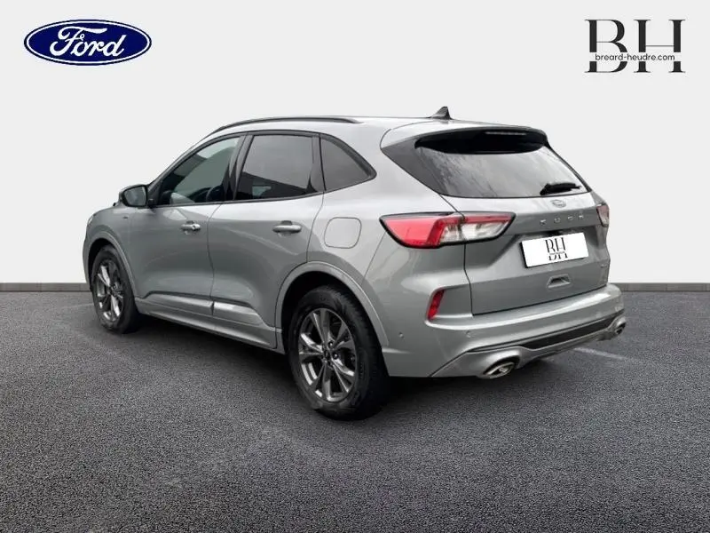 Vue 3/4 arrière droite d'un Ford Kuga gris Solar métallisé avec vitres arrière surteintées et double sortie d'échappement.