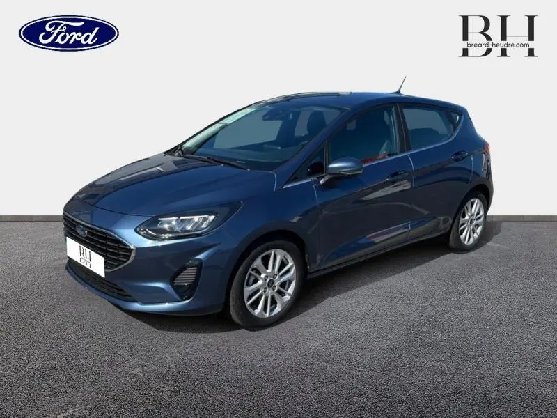 Ford Fiesta 1.0 EcoBoost Hybrid bleu azur métallisé vue 3/4 avant avec jantes alu et calandre chromée.