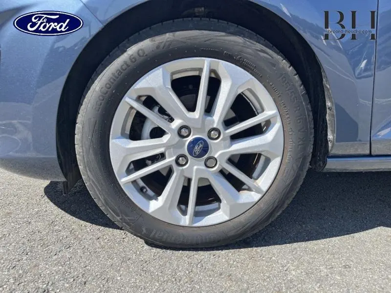 Gros plan sur la roue avant droite avec jante alu de la Ford Fiesta bleu azur métallisée 2022.