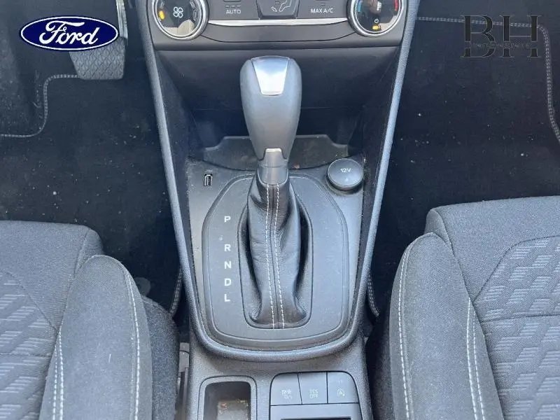 Levier de vitesses automatique en cuir noir au centre de la console d'une Ford Fiesta Titanium Business 2022, sièges tissu noir visibles.