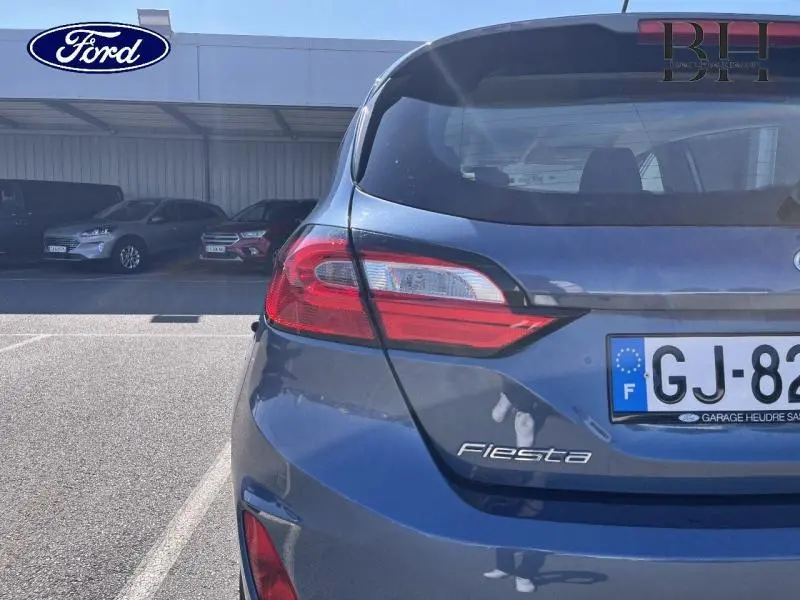 Vue arrière droite d'une Ford Fiesta 1.0 EcoBoost Hybrid 2022 en bleu azur métallisé avec feux arrière LED.
