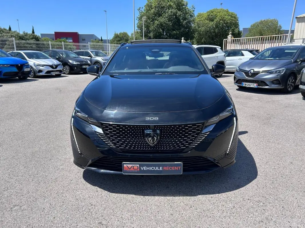 Peugeot 308 SW PHEV 225 e-EAT8 GT noir vue de face, avec calandre distinctive et barres de toit visibles.