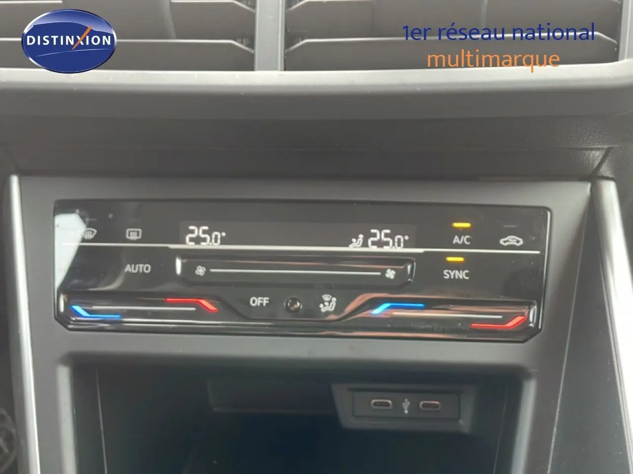 Panneau de commande de climatisation digitale de la Volkswagen Polo blanche, affichant 25°C en mode automatique.