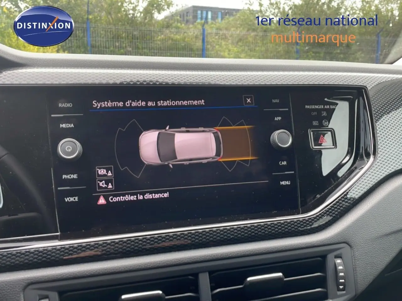 Écran central du tableau de bord d'une Volkswagen Polo blanche 2022 affichant le système d'aide au stationnement.