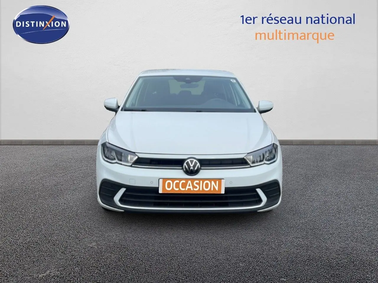 Vue frontale d'une Volkswagen Polo blanche avec plaque "OCCASION" sur fond neutre, éclairage LED visible.