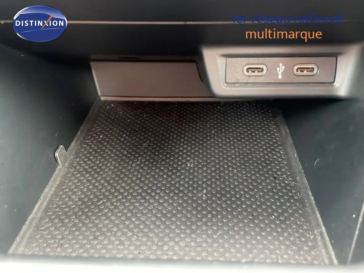 Gros plan sur la zone de rangement intérieure avec deux ports USB-C visibles dans une Volkswagen Polo blanche.