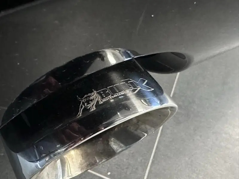 Gros plan sur l'embout d'échappement noir brillant avec logo Bull-X, accessoire distinctif d'un Audi TT Coupé 2002.