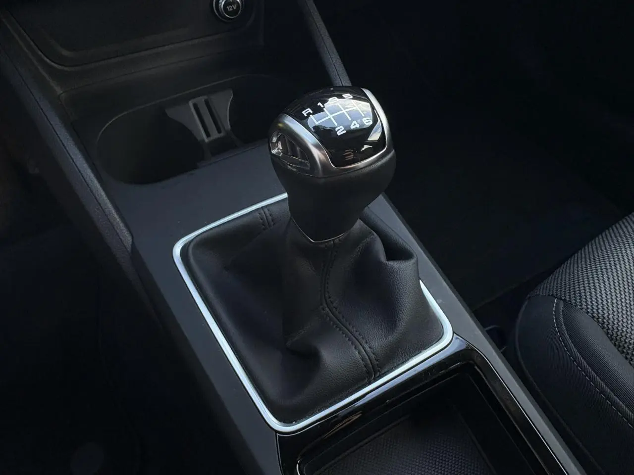 Gros plan sur le levier de vitesses manuel noir de l'Audi Q2 30 TDI S-Line, entouré de la console centrale sombre.