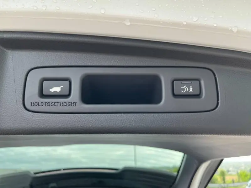 Gros plan sur les boutons de commande d'ouverture et fermeture électrique du coffre du Honda CR-V blanc Platine nacrée 2024.
