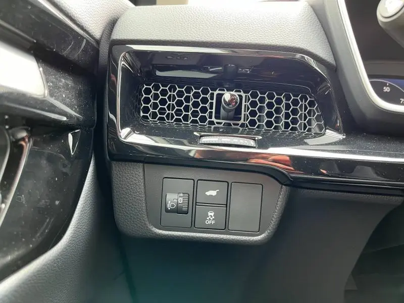 Détail intérieur côté gauche du tableau de bord du Honda CR-V blanc nacré 2024, avec grilles d’aération et boutons de réglage.