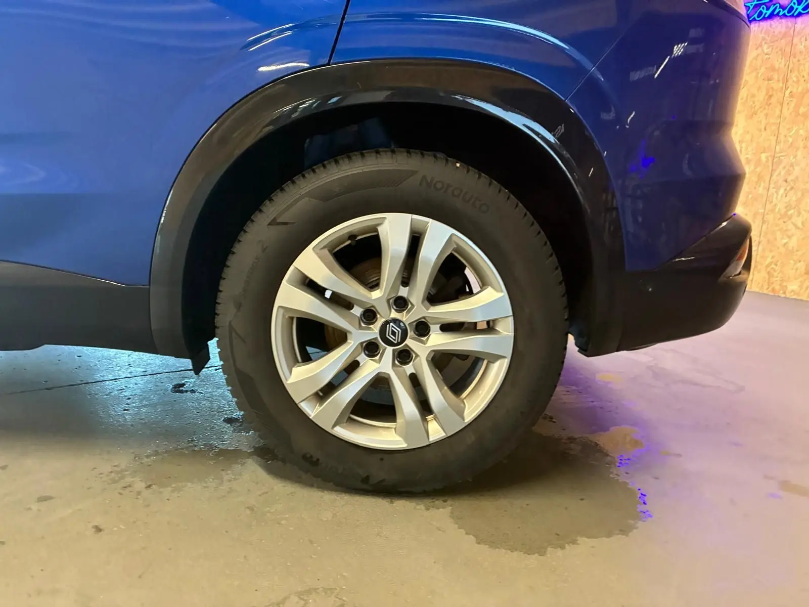 Gros plan sur la roue arrière droite d’un Renault Austral bleu 2024, soulignant la jante alliage et l’arche de roue noire.