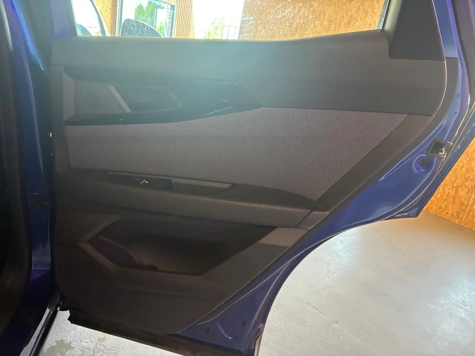 Vue intérieure de la porte arrière droite bleu du Renault Austral 2024, avec garniture tissu gris et éléments noirs.