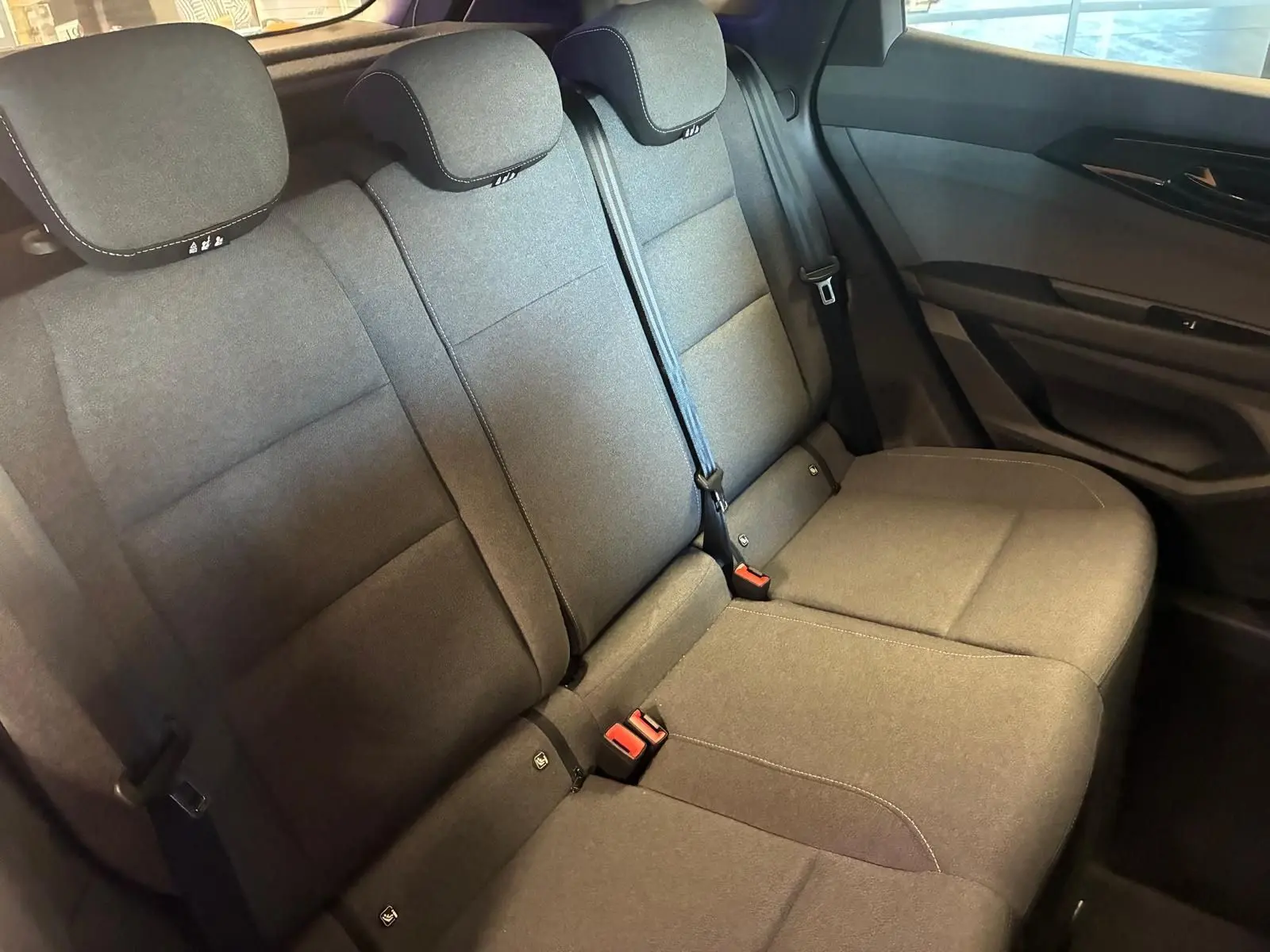 Vue intérieure du siège arrière en tissu gris noir du Renault Austral 2024, avec ceintures de sécurité et appuie-têtes visibles.