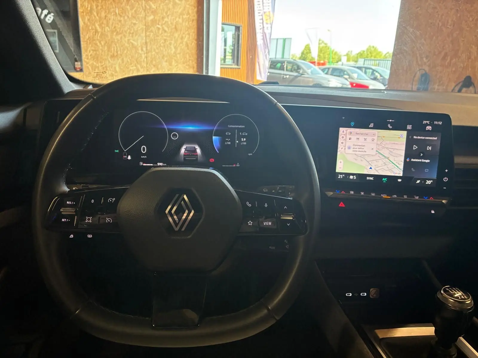 Vue intérieure centrée sur le volant noir de la Renault Austral 2024 avec tableau de bord numérique et écran tactile GPS.
