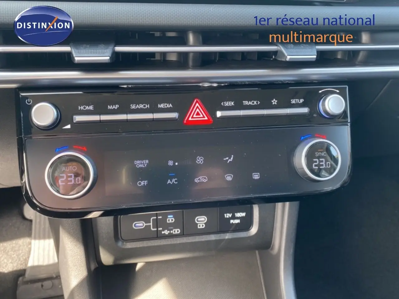 Tableau de bord du Hyundai Tucson gris Ecotronic, vue rapprochée sur la console centrale avec commandes climatisation et multimédia.