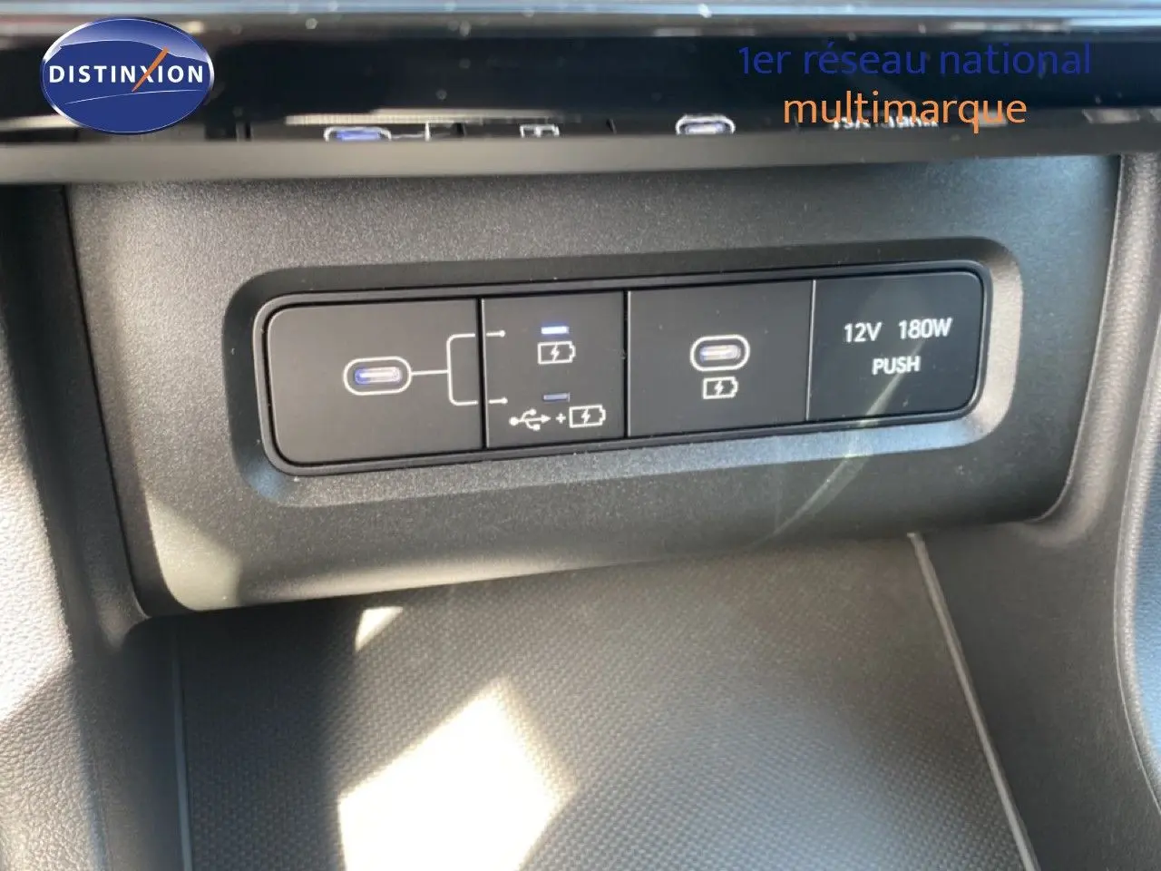 Vue rapprochée des ports USB et prise 12V du Hyundai Tucson gris Ecotronic Metal 2026, version hybride essence.
