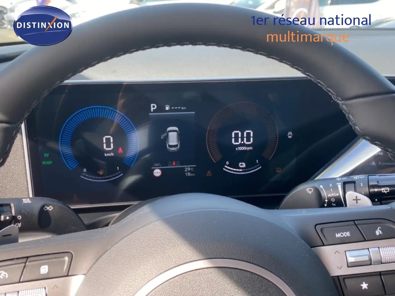 Vue rapprochée du tableau de bord numérique et du volant cuir noir du Hyundai Tucson 2026 hybride gris Ecotronic.