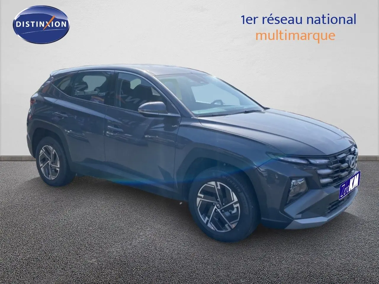 Hyundai Tucson gris Ecotronic Metal en 3/4 avant droit, SUV hybride avec jantes alliage et calandre distinctive.