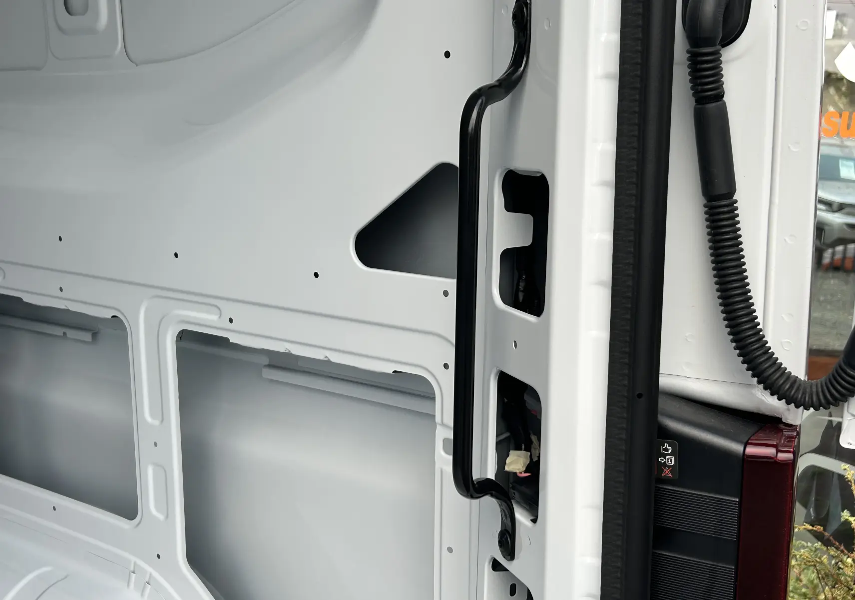 Vue intérieure de la porte arrière droite blanche du Renault Master Fourgon, montrant la poignée et la structure métallique.