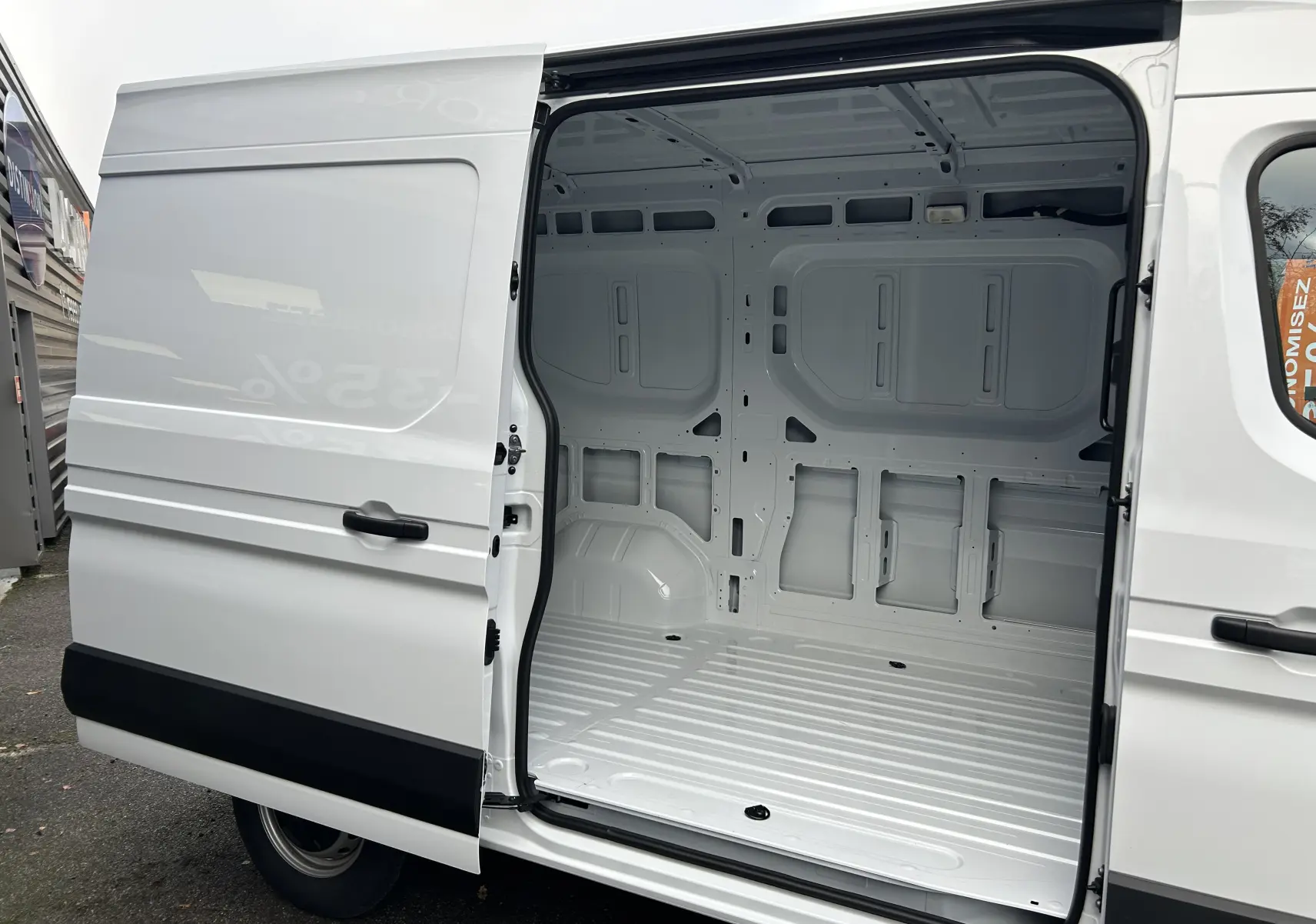 Vue latérale gauche du Renault Master blanc avec porte coulissante ouverte montrant l'intérieur vide du fourgon.