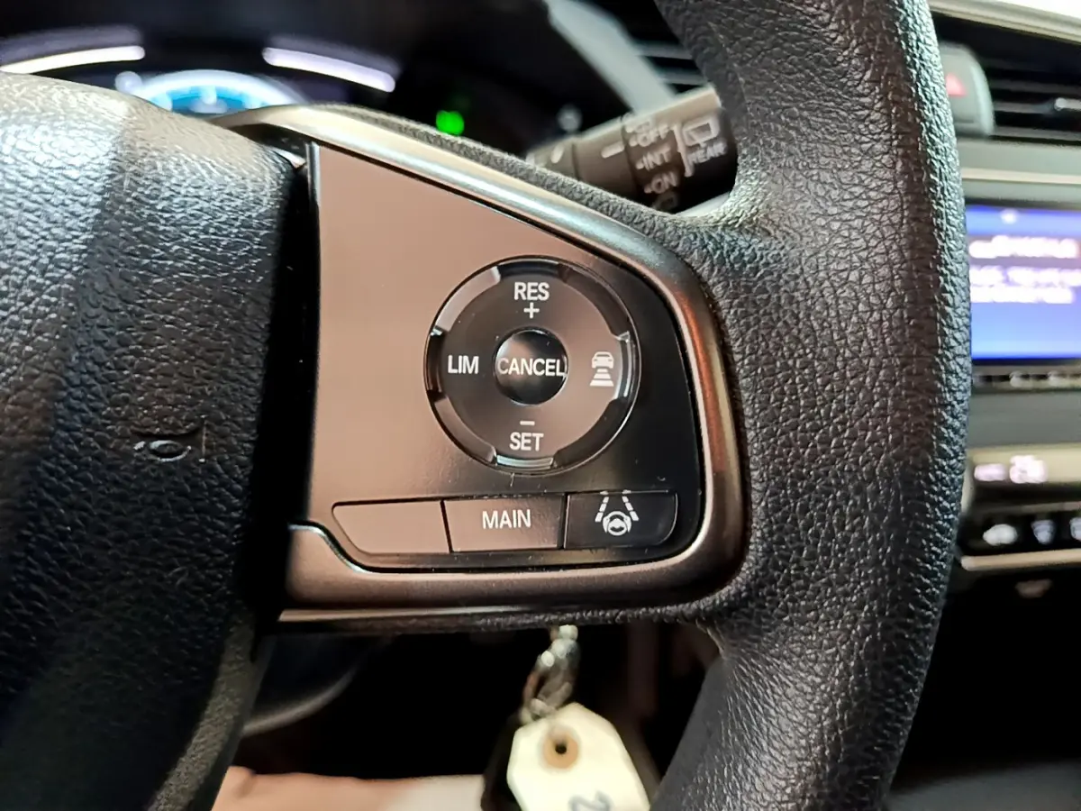 Gros plan sur les commandes du régulateur adaptatif au volant cuir d'une Honda Civic 1.0 i-VTEC Exclusive 2020.