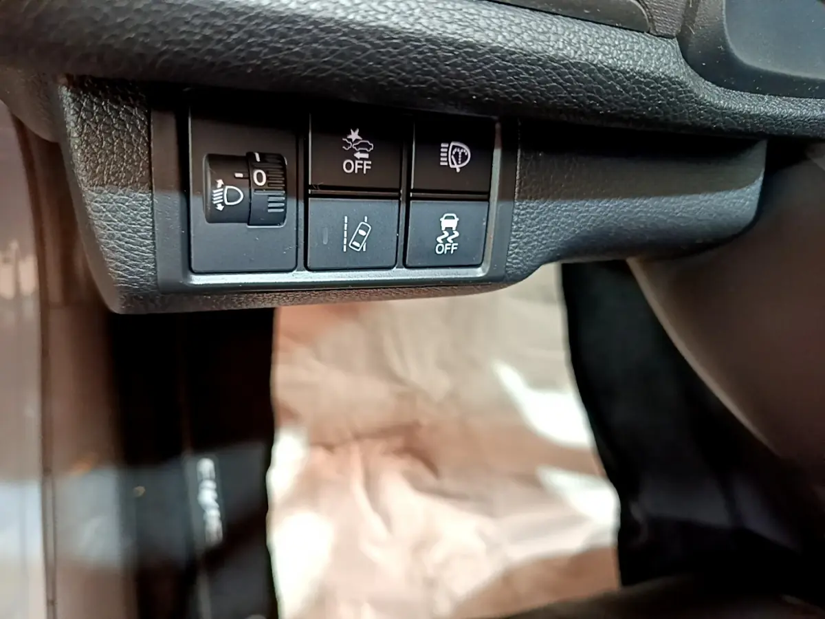 Gros plan sur les commandes noires sous le tableau de bord de la Honda Civic 1.0 i-VTEC Exclusive 2020.