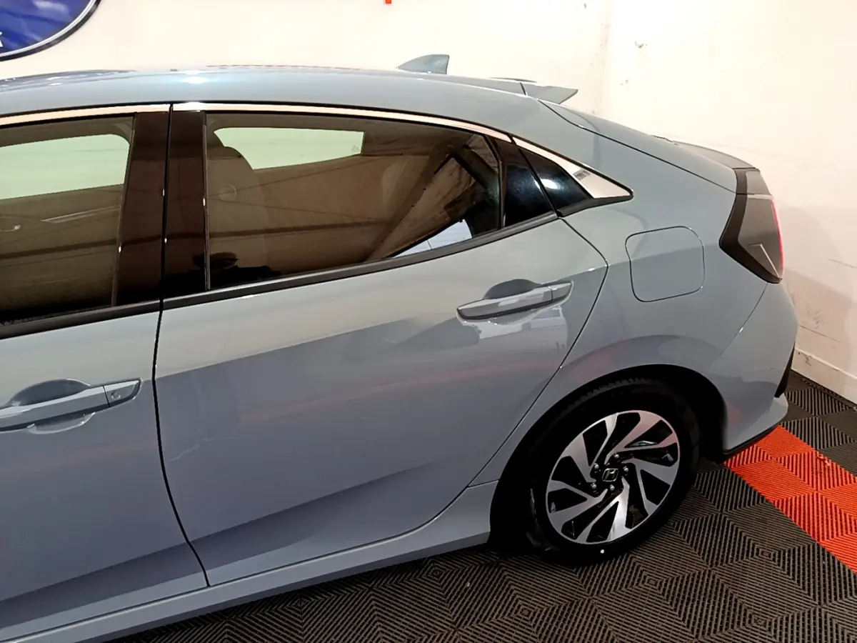 Vue latérale droite de la Honda Civic 1.0 i-VTEC Exclusive gris foncé, soulignant la porte arrière et la jante stylisée.