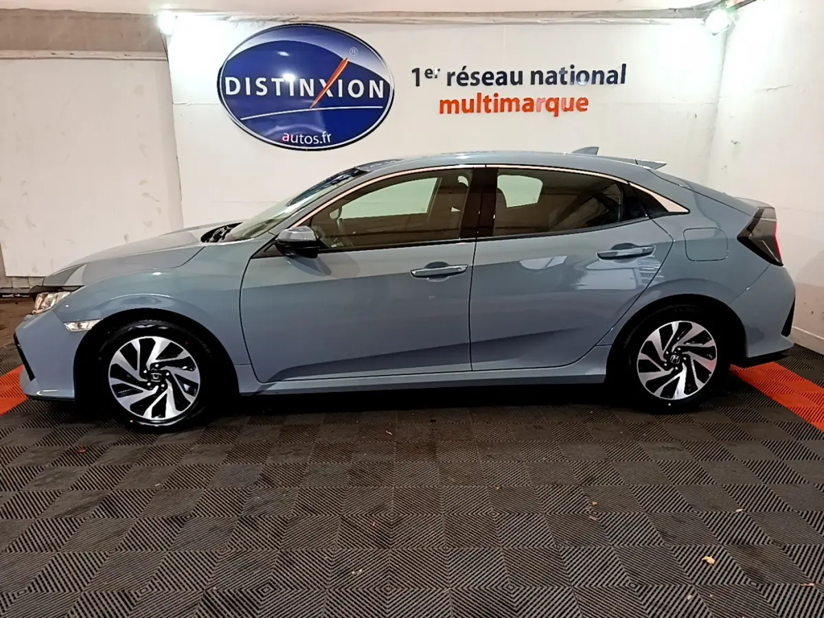 Profil côté gauche d'une Honda Civic 1.0 i-VTEC Exclusive gris foncé, avec jantes alliage et vitres teintées.