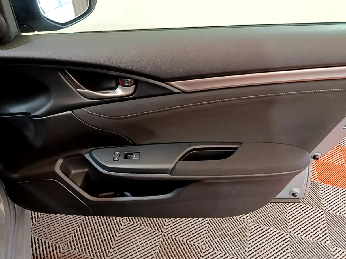 Panneau de porte côté gauche intérieur noir de la Honda Civic 1.0 i-VTEC Exclusive 2020, avec poignée argentée et commandes vitres.