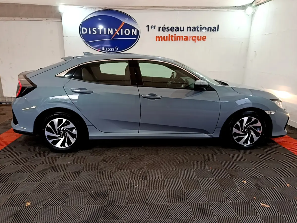 Profil côté droit d'une Honda Civic 1.0 i-VTEC Exclusive gris foncé, avec jantes alliage et feux arrière distinctifs.