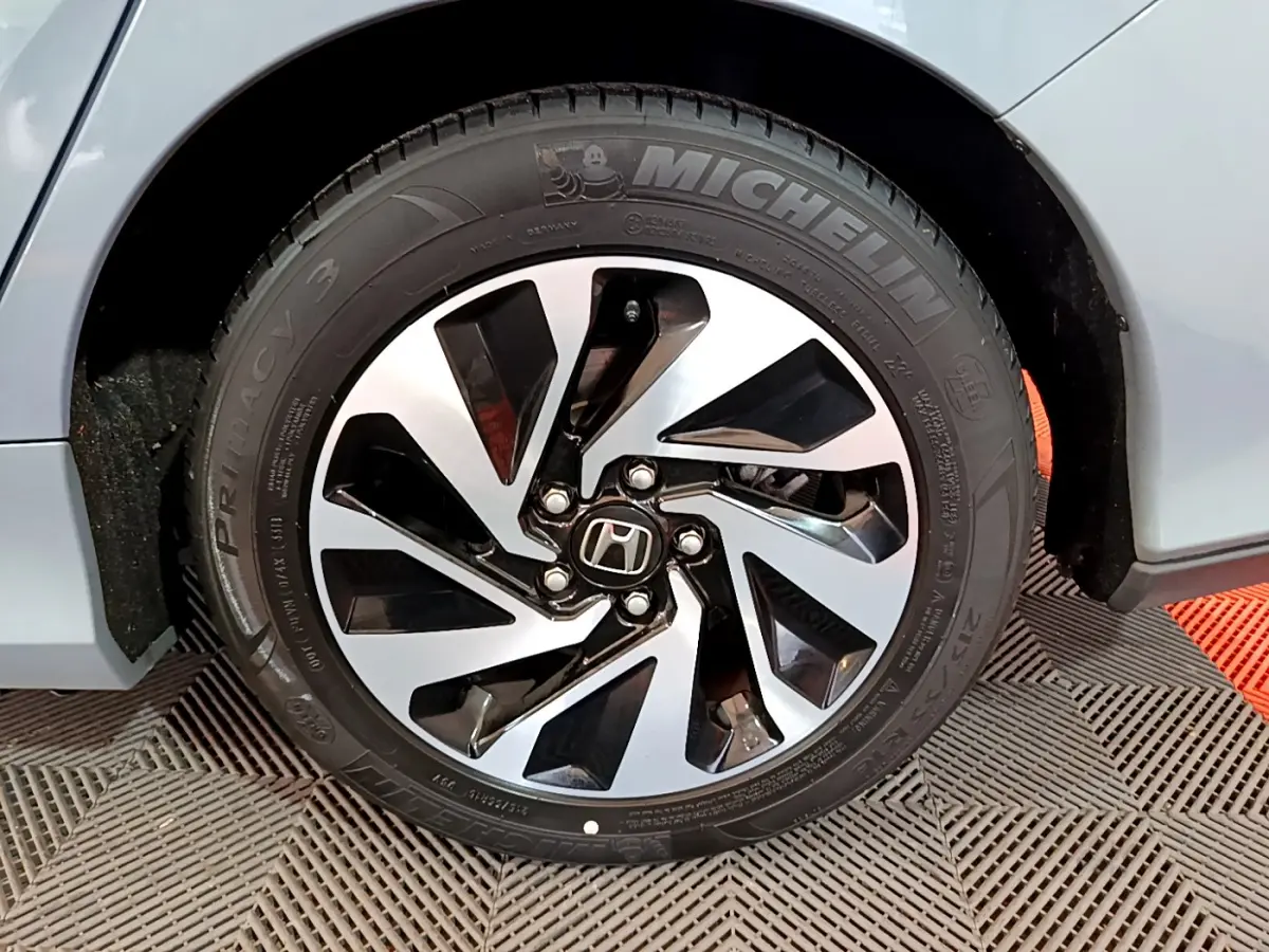 Gros plan sur la roue avant droite gris foncé de la Honda Civic 1.0 i-VTEC Exclusive avec jante au design moderne noir et argent.