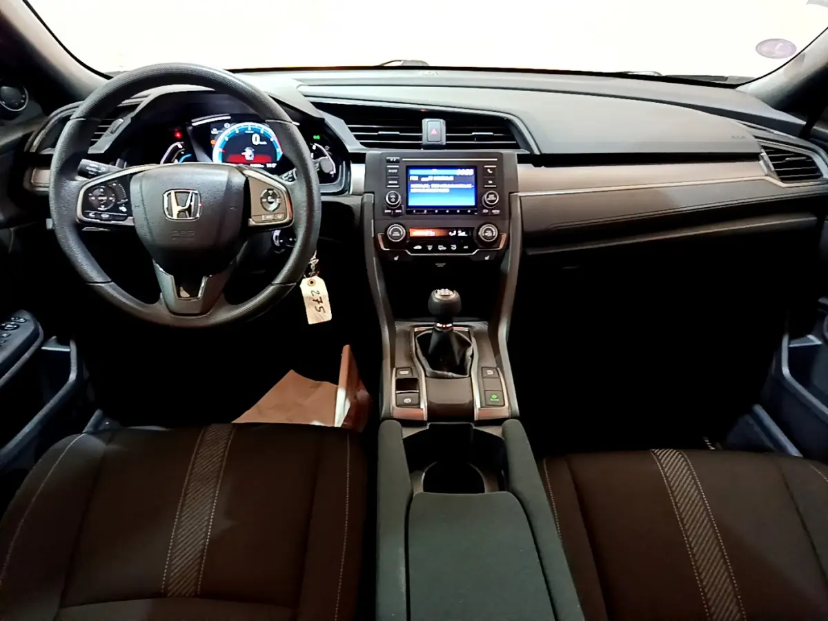 Intérieur avant de la Honda Civic 1.0 i-VTEC Exclusive 2020, tableau de bord noir avec volant cuir et boîte manuelle.