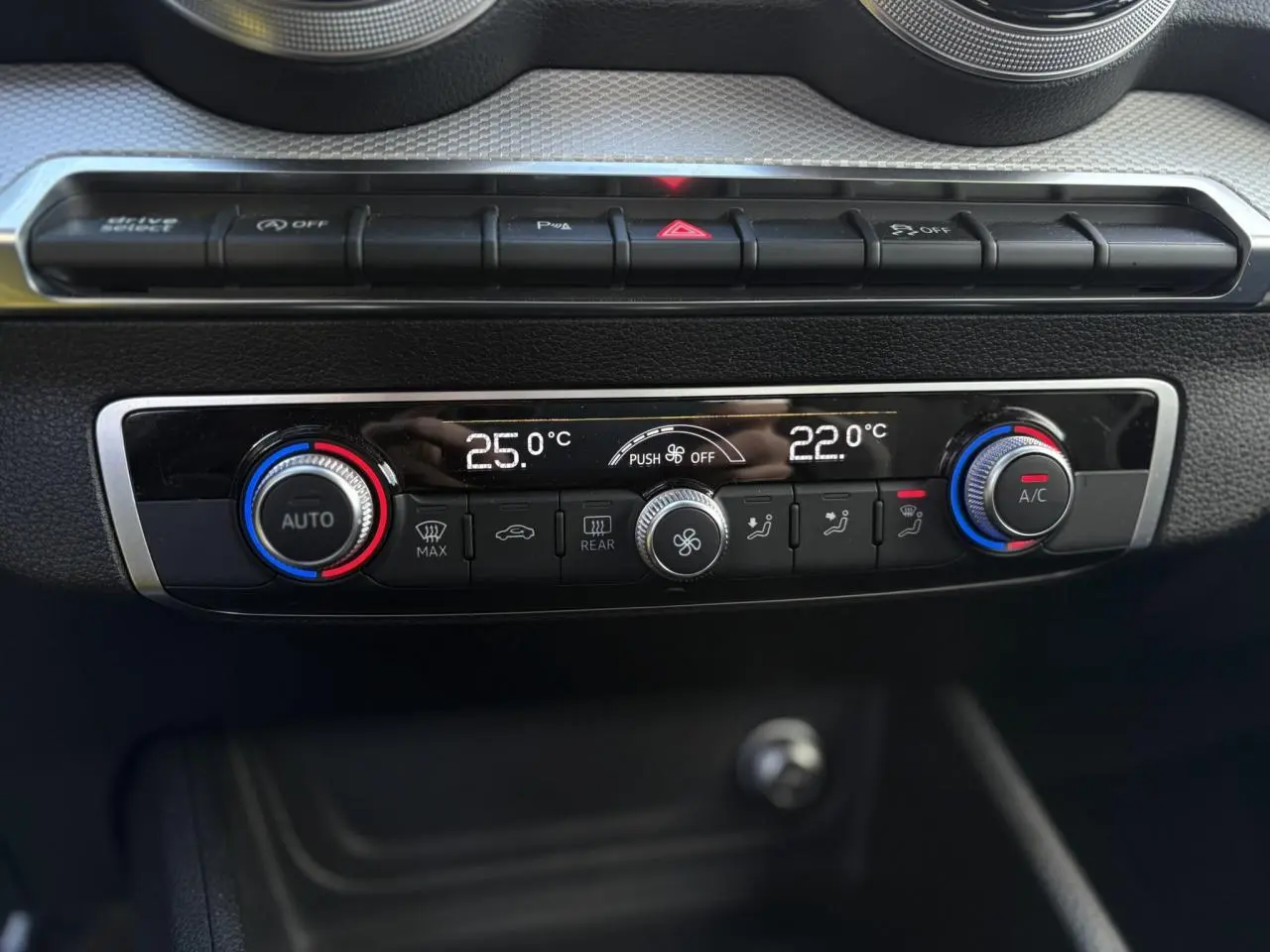 Vue rapprochée de la console centrale de l’Audi Q2 30 TDI S-Line 2025, affichant la climatisation automatique bi-zone.
