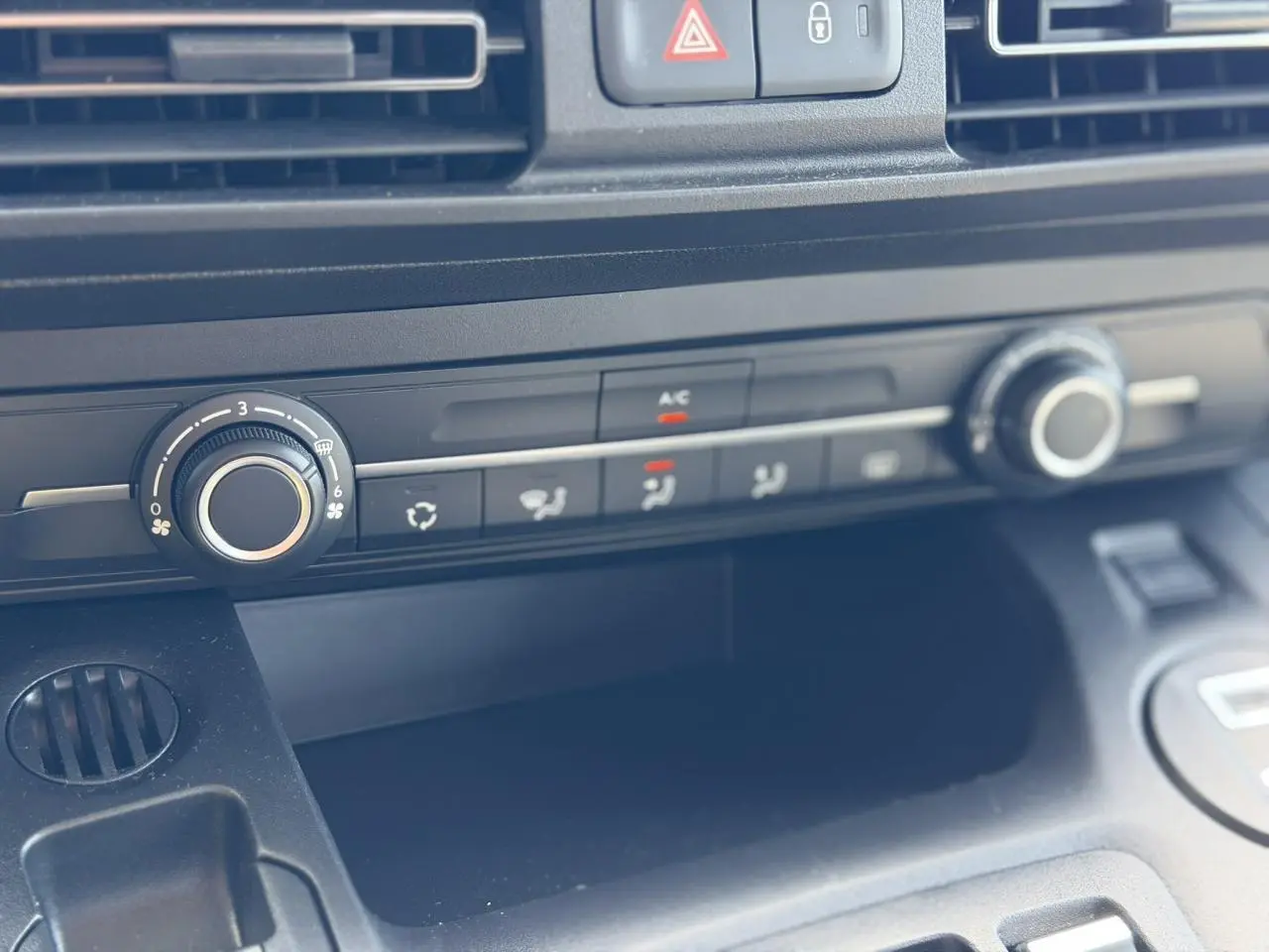 Détail de la console centrale noire du Citroën Berlingo 2025, avec commandes de climatisation et ventilation.