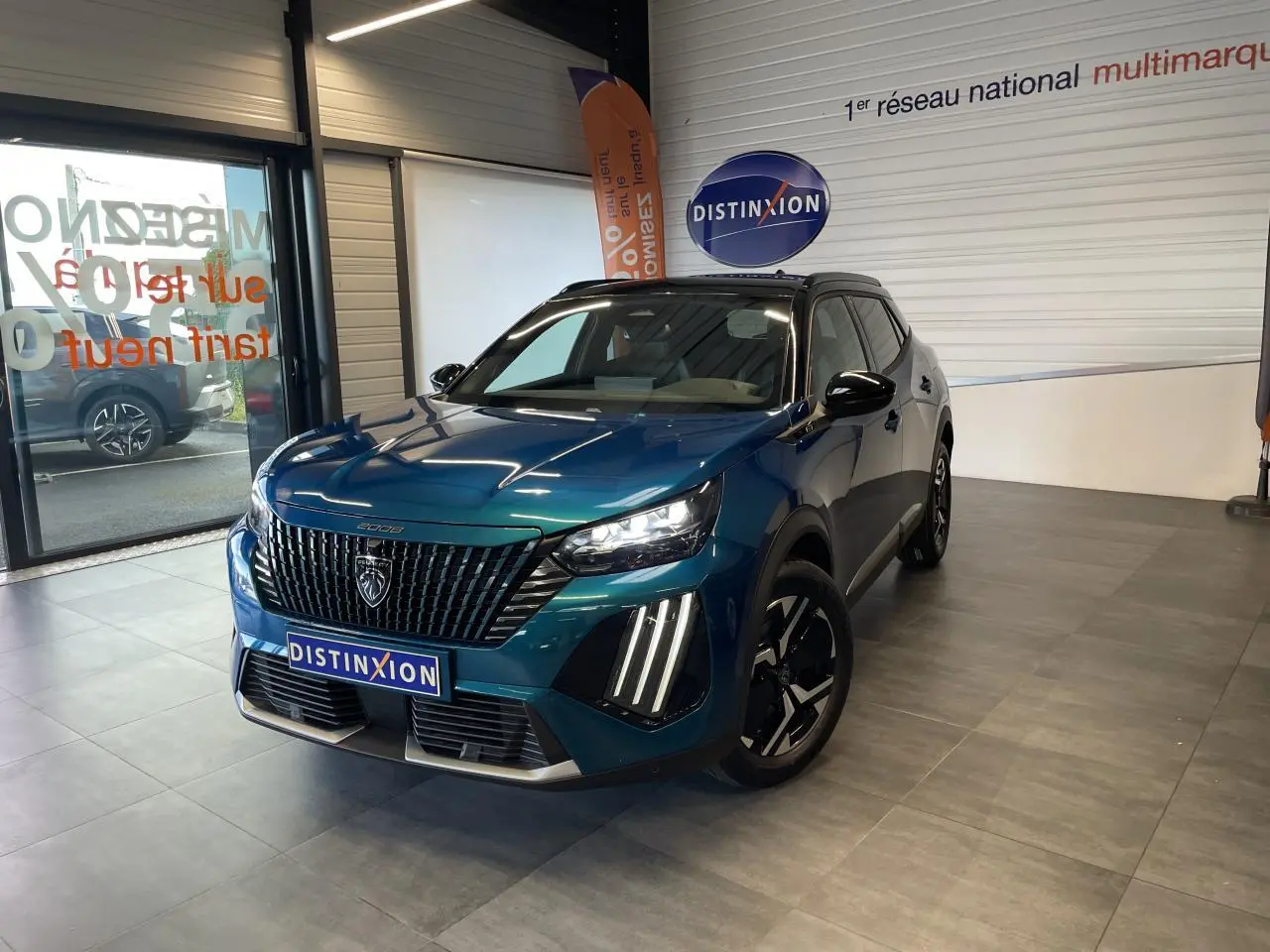Peugeot 2008 hybride bleu en 3/4 avant droit, avec calandre noire verticale et feux LED distinctifs en griffes.