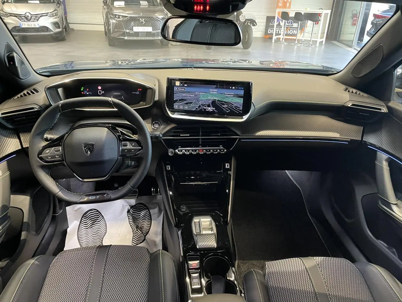 Vue intérieure avant du Peugeot 2008 bleu 2026, avec tableau de bord numérique et écran tactile central.